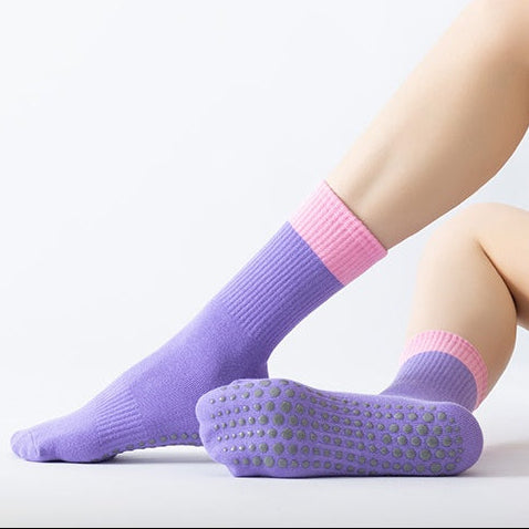 Purple socks with pink accents worn by a person on a white background
